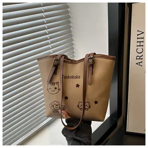 Detail of large tote bag showing brown leather strap with adjustable metal buckle