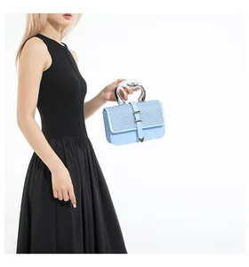 Détail du sac en cuir tressé bleu clair avec une poignée métallique argentée moderne