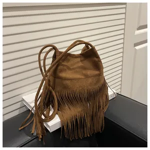 Vue détaillée du sac seau bohème en daim marron foncé avec de longues franges