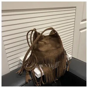 Vue détaillée du sac seau en daim marron foncé avec de longues franges bohèmes et bandoulière