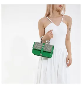 Détail du sac en cuir vert avec rabat en tissu à chevrons et poignée en métal argenté