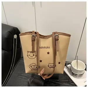 Detailed view of the cute cat print and smooth faux leather texture on the bucket bag