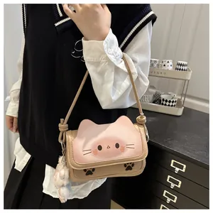 Détail du rabat en forme de chat et du pompon en peluche sur le sac à bandoulière