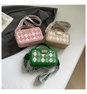 Detailed view of three checkered crossbody bags in pink, beige, and green with wide straps
