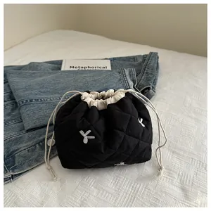 Macro detail of black quilted drawstring pouch with white rabbit embroidery and soft lining