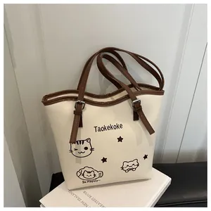 Close-up of cute cat illustrations and logo print on cream bucket bag texture