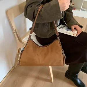 Brown suede hobo shoulder bag shown on model for a trendy and casual winter look