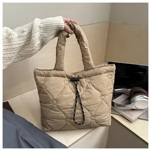 Detail of khaki quilted bucket bag with heart stitching and striped drawstring closure