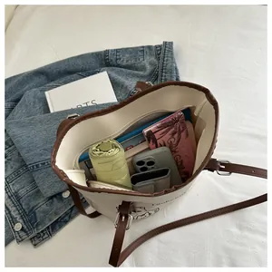 Spacious interior of beige tote bag showing daily essentials and zip pocket