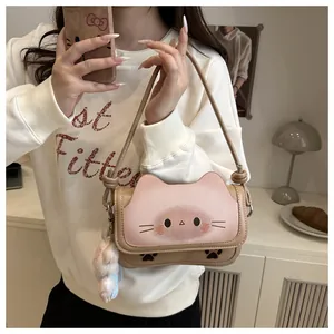 Gros plan du sac à bandoulière chat rose et beige avec un porte-clés pompon en peluche