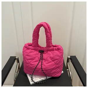 Detail of hot pink quilted dumpling bag with heart patterns and textured drawstring closure