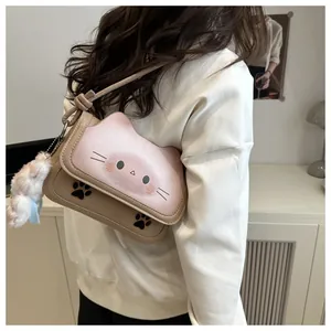 Vue détaillée du sac à bandoulière chat avec breloque en peluche et motifs de chat