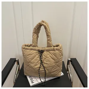 Detail of light brown bucket bag featuring heart quilted patterns and drawstring closure