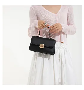 Detailed view of elegant black leather handbag with classic light gold square metal buckle