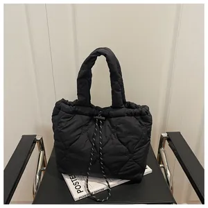 Close-up of black quilted handbag featuring unique heart-shaped stitching and drawstring closure