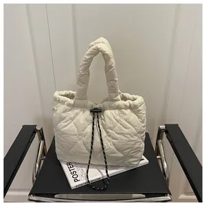 Detail of cream quilted bucket bag with heart embroidery and drawstring closure