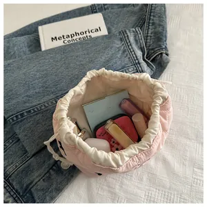Detailed view of pink quilted drawstring makeup bag showing storage capacity for cosmetics