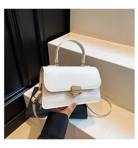 Close-up of minimalist white square bag with premium gold metal clasp on a display stand