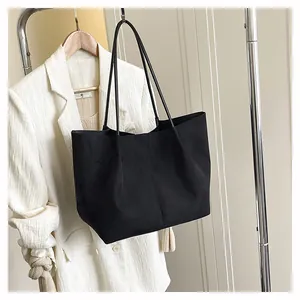 Détail du grand sac cabas noir mat en suédine avec de longues doubles bandoulières