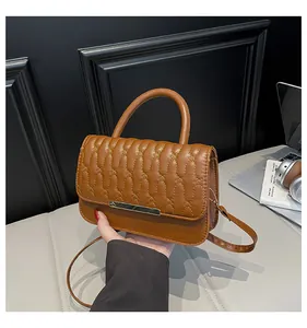 Close-up of brown quilted leather bag with elegant stitching and golden metal lock