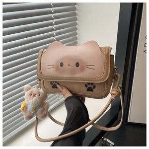 Détail d'un sac bandoulière tête de chat avec charm ours en peluche et similicuir lisse