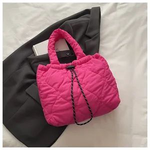 Detail of rose pink quilted bucket bag featuring heart embroidery and drawstring closure