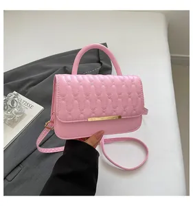 Detail of pink embroidered handbag with wavy texture and golden metallic buckle