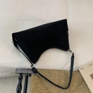 Close-up of black suede crescent bag with silver metallic hardware and slim strap