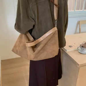 Retro brown suede hobo bag shown on shoulder with minimalist vintage styling