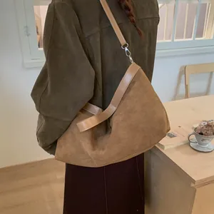 Detail view of large caramel suede tote bag featuring a silver buckle and soft texture
