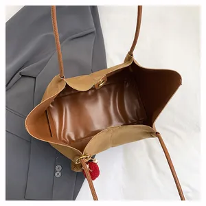 Vue de dessus du grand sac cabas en daim marron avec fermoir magnétique et intérieur