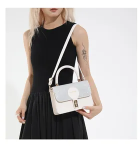 Detail of sequined flap and golden rotating lock on the white leather handbag
