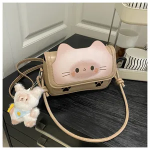 Détail du sac bandoulière en cuir beige avec rabat chat et breloque lapin en peluche