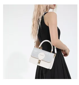 Detail of white leather handbag featuring silver sequins and a gold twist lock closure