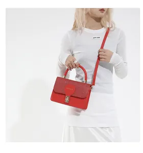 Detail of red sequined handbag featuring a gold buckle and luxury leather texture