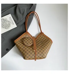 Detail view of the vintage plaid leather bucket bag with matching round pouch attachment