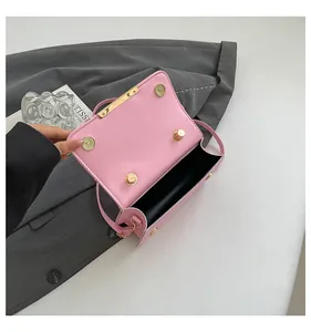 Detail of pink leather handbag showing dual magnetic closures and spacious black interior