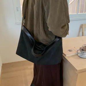 Detailed side view of large black tote bag with leather trim and adjustable strap