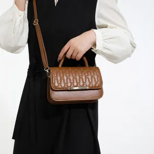 Brown quilted PU leather handbag with gold metal clasp and adjustable shoulder strap