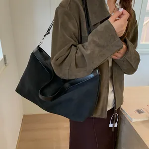 Detailed side view of a large black vintage tote bag with matte texture on a model