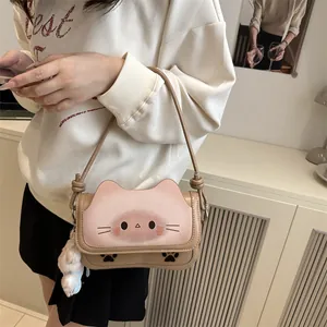 Sac bandoulière chat rose et kaki avec charm en peluche porté par un mannequin femme