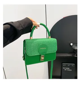 Detail of green fashion crossbody bag with glitter flap and golden twist lock closure