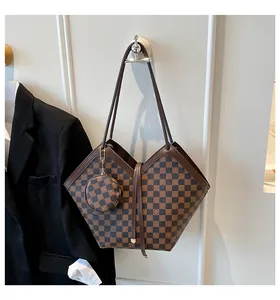 Close-up of checkered bucket bag with matching round coin purse and slim brown strap