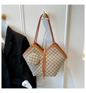 Detail of large checkered tote bag and round coin purse hanging on a white wall