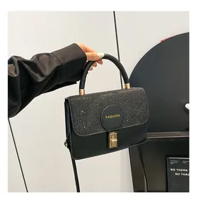 Detail of glitter flap black crossbody bag with gold lock and fashion leather handle