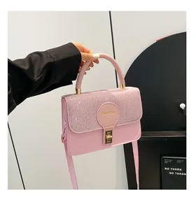 Detail of pink clasp bag featuring glitter flap and golden Fashion logo engraving