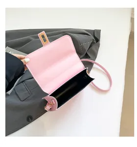 Detail of pink PU leather bag interior with black lining and gold square lock