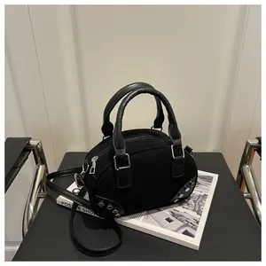 Dettaglio borsa bowling in camoscio nero con borchie metalliche argentate e zip