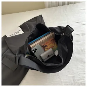 Interior detail of large black nylon messenger bag with storage for phone and books