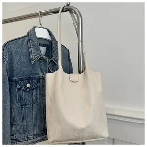 Detail of cream minimalist tote bag with matte texture and magnetic clasp on metal hanger